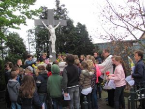 Kinderen Velddriel leggen bloemen bij het kruis